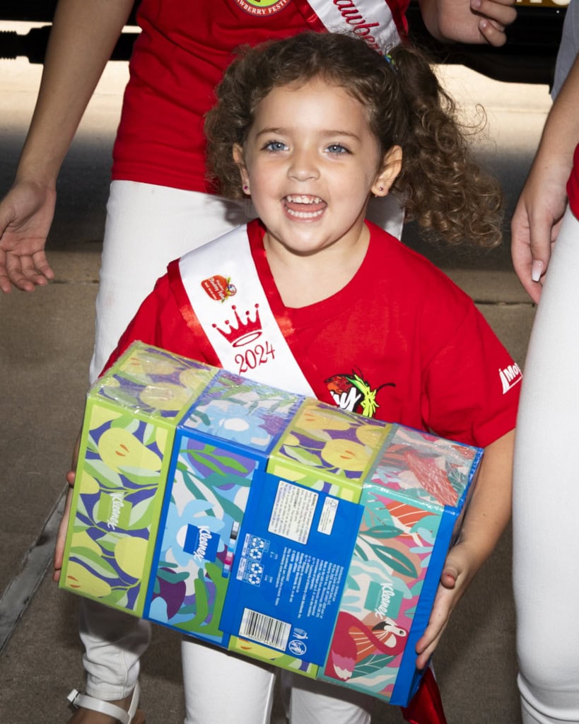 A young girl carries school supplies as part of Pasadena's Fill the Bus drive.